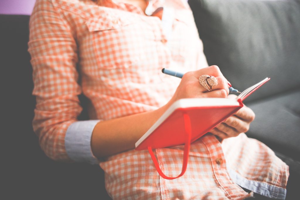 A woman writing in notebook.